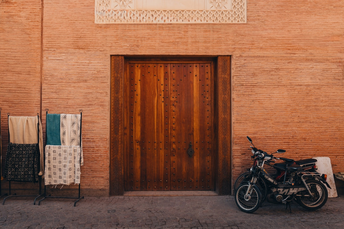 Wooden door with textiles and scooter outside