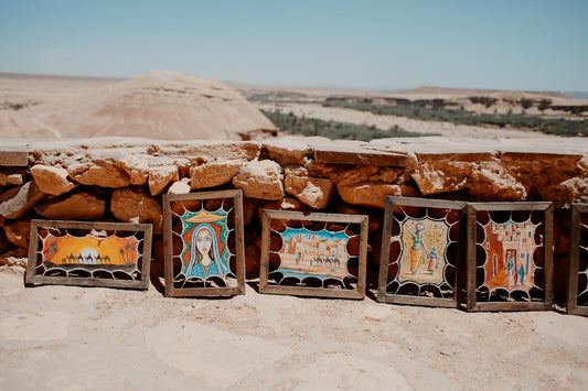 Framed artworks displayed against a desert landscape.