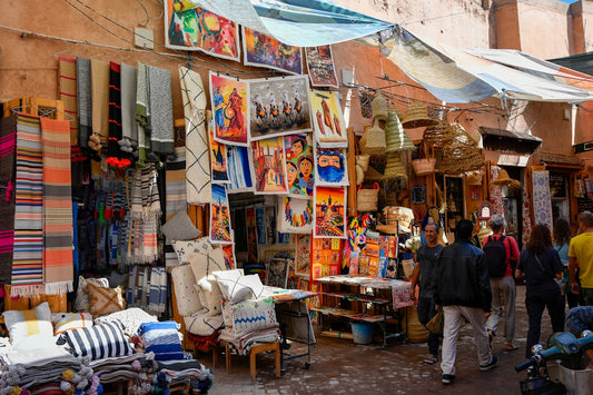 Colorful market stalls selling textiles and artwork in morocco.